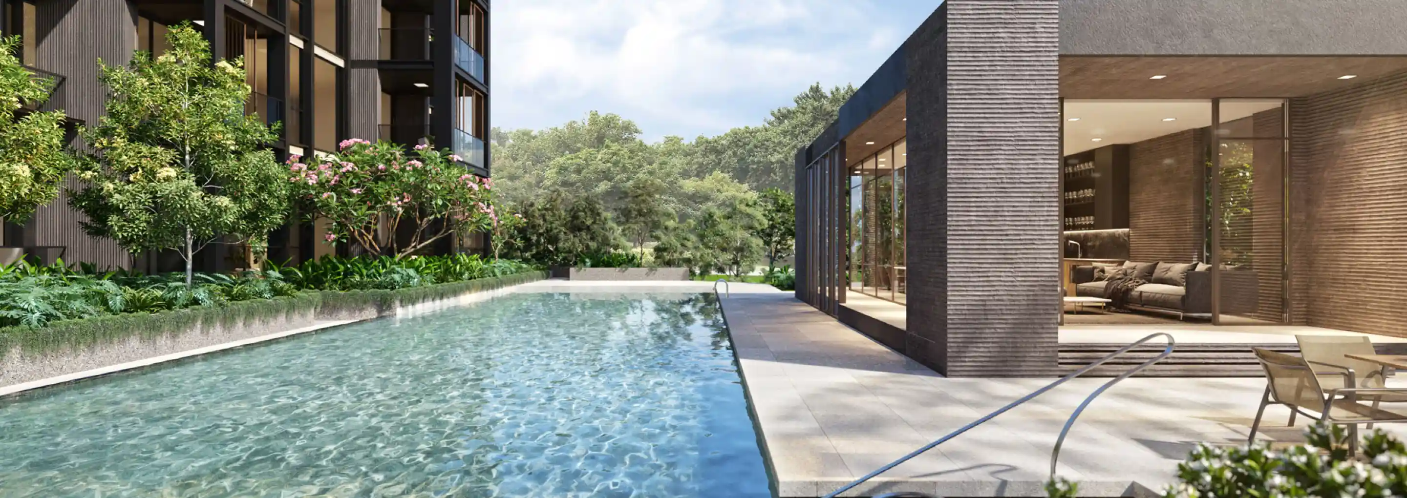A serene swimming pool beside the clubhouse, surrounded by green foliage. The pool area includes a lounging area, offering a peaceful retreat amidst nature.